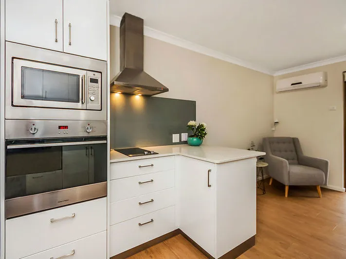 Modern living with timber floors and stone benchtops.