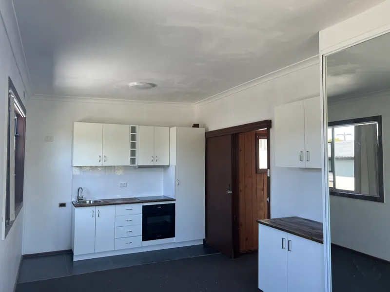 Open plan studio with private ensuite, kitchen - mirrored built in robes.
