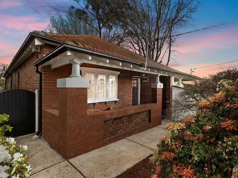Full brick residence exudes charm amid lush garden oasis