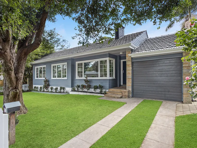 A charming cottage, beyond a white picket fence.