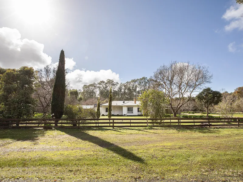 Lush lawn and beautiful trees surrounding this fresh timber-framed home